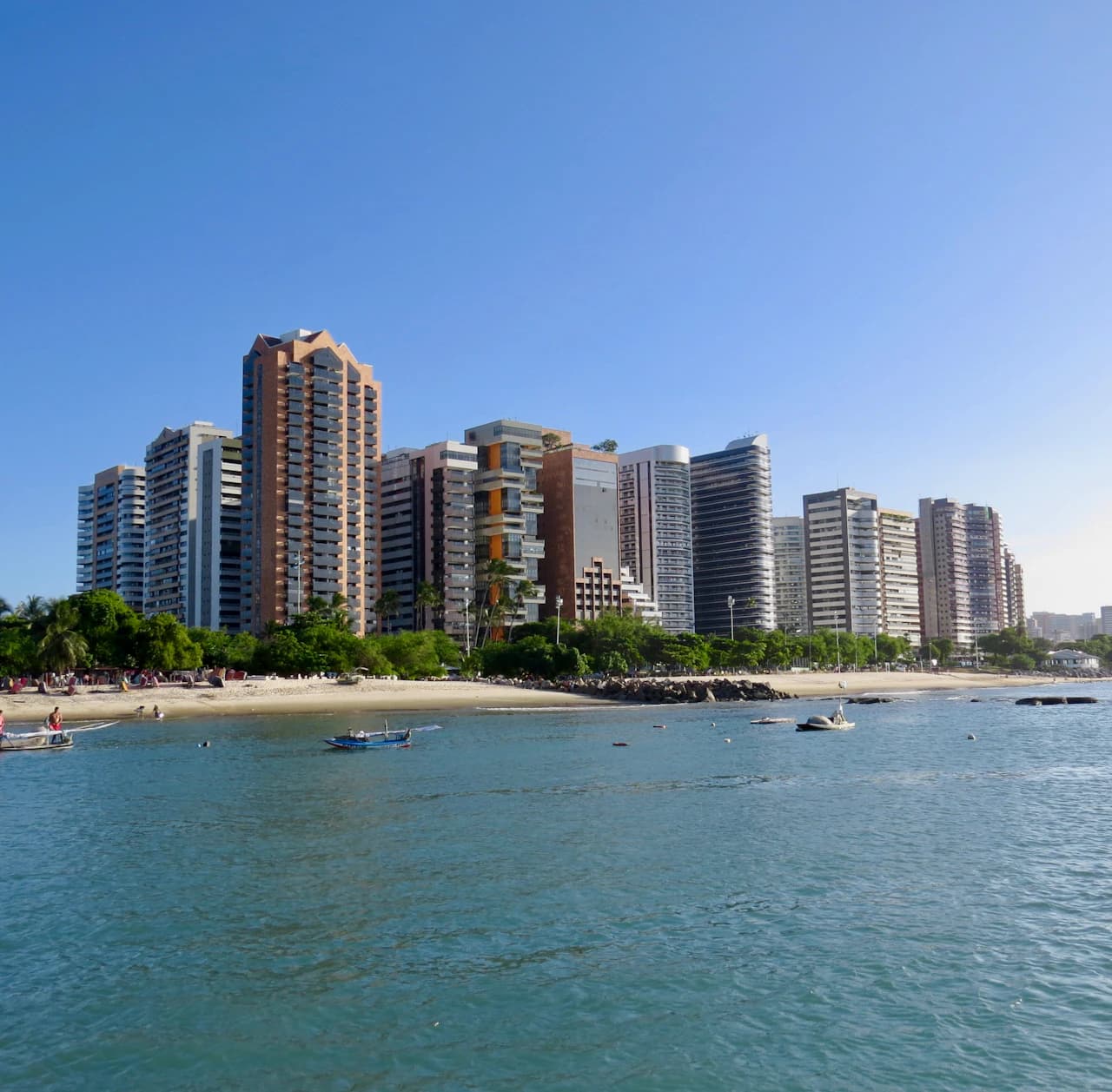 Orla de Fortaleza com edifícios, faixa de areia e mar